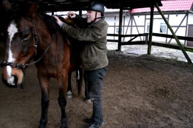 Jeździec stoi przy koni i tłumaczy
